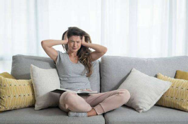 mulher com as mãos nos ouvidos por causa de barulho