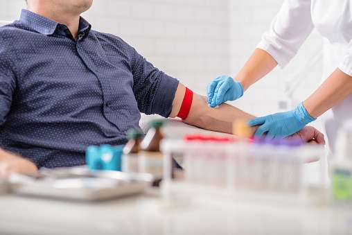 Homem sentado para doação de sangue