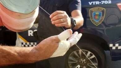 mãos com curativos e GCM segurando linha de pipa com cortante